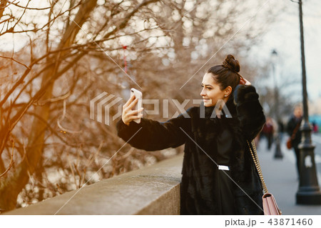 woman using her cell phone while walking through Paris woman using her cell phone while walking through Paris 43871460