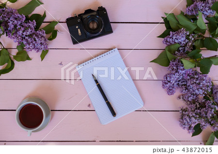on the white table lilac, gift, notebook, cup of tea 43872015