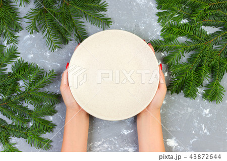 female hands holding an empty white plate female hands holding an empty white plate 43872644