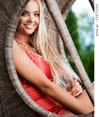 Young lady in red dress with luxury jewelry in garden 43873204