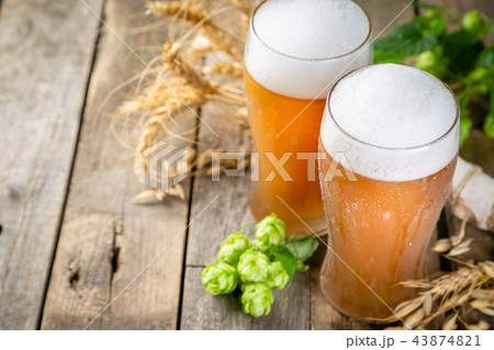 Beer and ingredients hops, wheat, barley on wood background 43874821