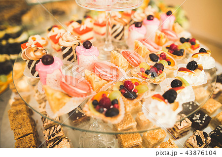 Delicious sweets on wedding candy buffet with desserts, cupcakes Delicious sweets on wedding candy buffet with desserts, cupcakes 43876104