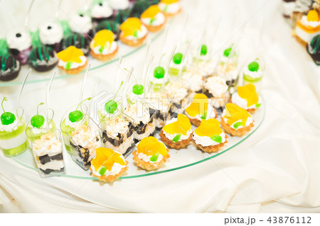 Delicious sweets on wedding candy buffet with desserts, cupcakes Delicious sweets on wedding candy buffet with desserts, cupcakes 43876112