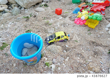 children toys scattered on the sandy beach children toys scattered on the sandy beach 43876627