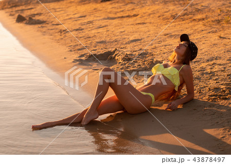 young sexy girl at sunset at the beach 43878497