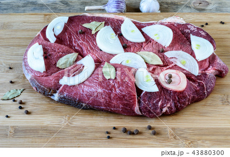 Raw beef meat with laurel leaves, black peppercorns and onion sl Raw beef meat with laurel leaves, black peppercorns and onion sl 43880300