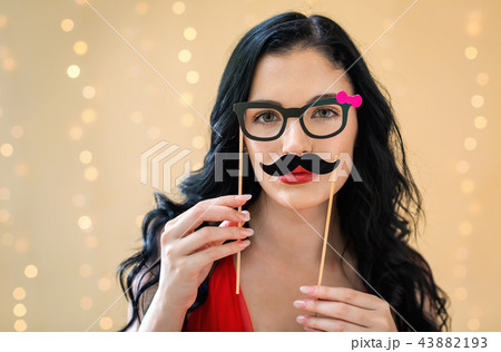 Young woman with paper glasses and mustache sticks Young woman with paper glasses and mustache sticks 43882193