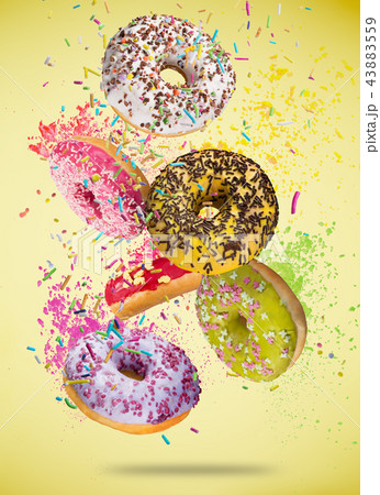 Tasty doughnuts in motion falling on pastel blue background. Tasty doughnuts in motion falling on pastel blue background. 43883559
