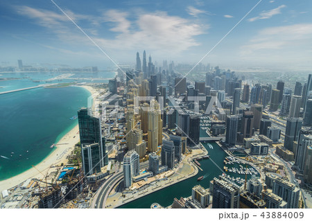 Aerial view of modern skyscrapers and sea in the background in Dubai, UAE. 43884009