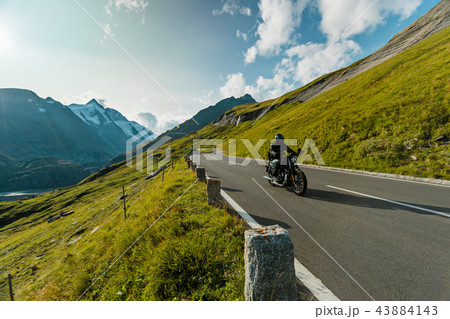 Motorcycle driver riding in Alpine highway on famous Hochalpenstrasse, Austria, Europe. 43884143