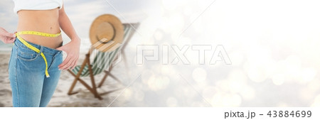 Woman measuring weight with measuring tape on waist on Summer beach with transition 43884699