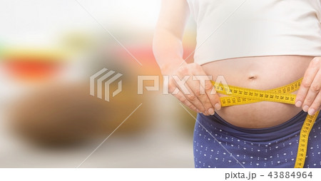 Woman measuring weight with measuring tape on waist on Summer beach 43884964