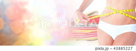 Woman measuring weight with measuring tape on waist on Summer beach with transition Woman measuring weight with measuring tape on waist on Summer beach with transition 43885227