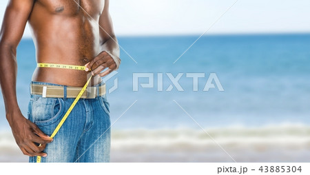 Man measuring weight with measuring tape on waist on Summer beach 43885304