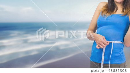 Woman measuring weight with measuring tape on waist on Summer beach 43885308