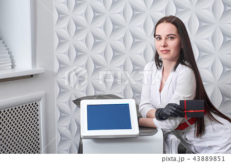 cosmetologist with IPL cosmetology device. Hair laser removal service. Cosmetic LED laser device for 43889851