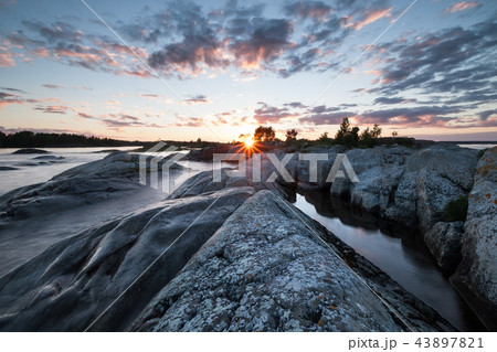 Sunset on lake with stony coast landscape 43897821