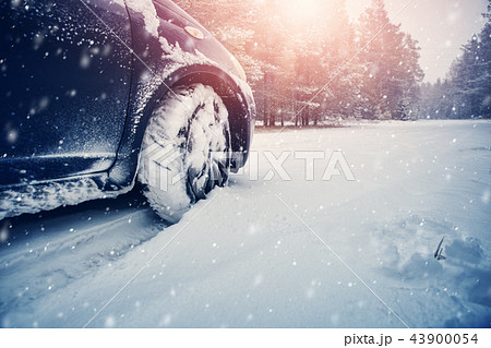 Car tires on winter road covered with snow Car tires on winter road covered with snow 43900054