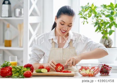 woman is cooking vegetables woman is cooking vegetables 43901458