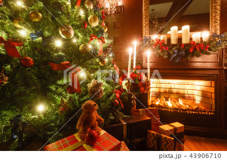 gifts at the Christmas tree. Christmas evening by candlelight. classic apartments with a fireplace. gifts at the Christmas tree. Christmas evening by candlelight. classic apartments with a fireplace. 43906710