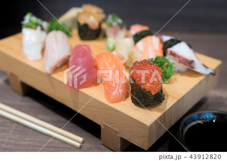 Close-up sushi and sashimi mixed on wooden plate 43912820