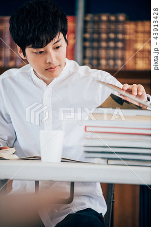 図書館でレポートを書く男性 43913428