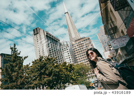 upward view of woman standing in street. 43916189