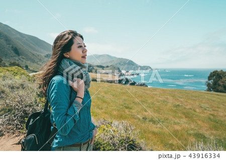 girl standing on a coast feeling peaceful 43916334