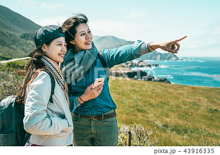 friends looking into ocean standing on coast 43916335