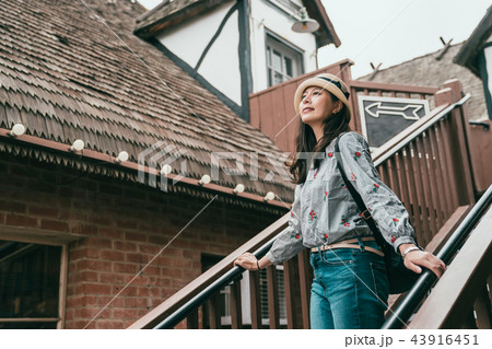 woman standing on stairs and looking upward 43916451