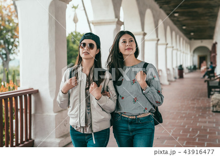 friends walking in hallway and looking around. 43916477