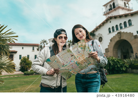 sisters visiting beautiful building with guide map 43916480