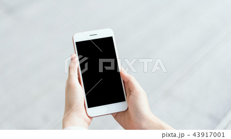 woman using smartphone on staircase in public area 43917001