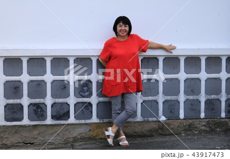 松合地区の土蔵白壁の家でポーズをとる60歳代の中高年女性 松合地区の土蔵白壁の家でポーズをとる60歳代の中高年女性 43917473