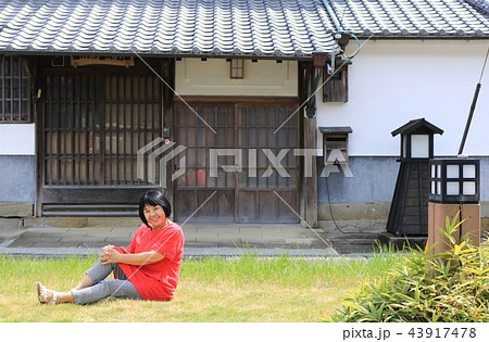 松合地区の土蔵白壁の家でポーズをとる60歳代の中高年女性 43917478