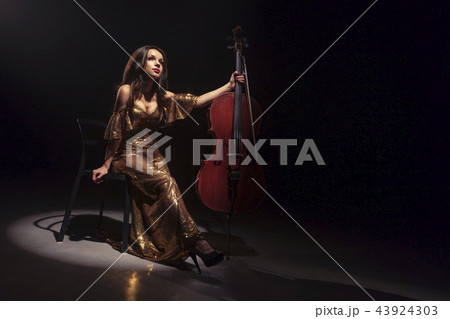 The cellist performs on stage. 43924303