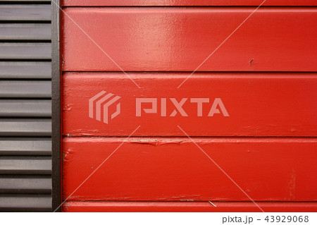 赤くペイントされた板壁とシャッター 43929068