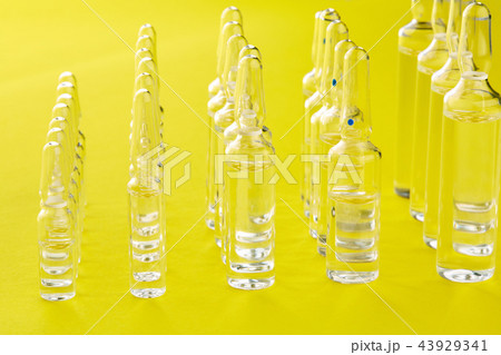 Ampoules with medicine on yellow background. Ampoules with medicine on yellow background. 43929341