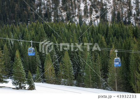Cable cars drifting apart over snowy forest 43932233