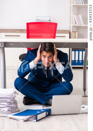 Tired exhausted businessman working overtime in office Tired exhausted businessman working overtime in office 43933555