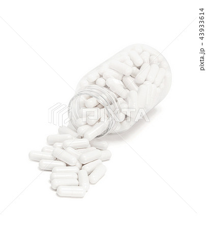 white medicine capsules spill out from bottle white medicine capsules spill out from bottle 43933614