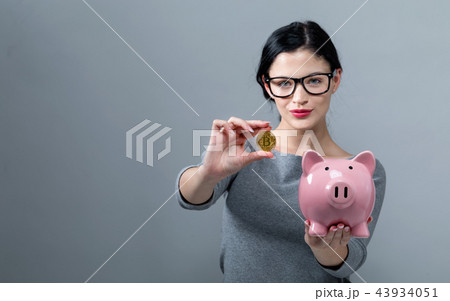 Young woman with bitcoin and a piggy bank 43934051