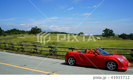 阿蘇の牧場と赤いスポーツカー 九州熊本県の阿蘇山 阿蘇の牧場と赤いスポーツカー 九州熊本県の阿蘇山 43935712