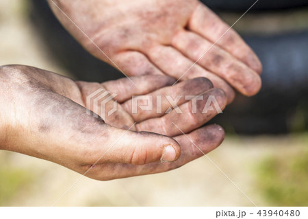 Closeup of young man dirty hands and tyre outdoors Closeup of young man dirty hands and tyre outdoors 43940480
