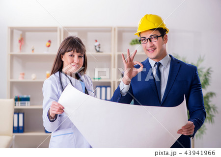 Doctor discussing new hospital plan with architect 43941966