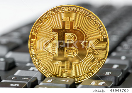 Golden Bitcoin on top of computer keyboard 43943709