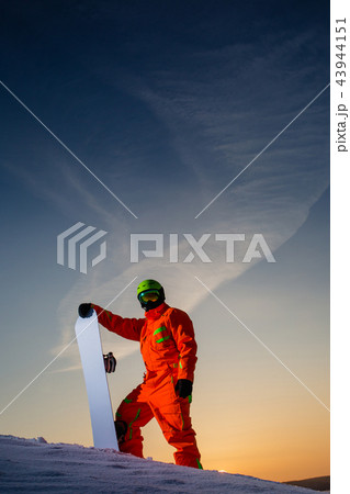 Snowboarder on the top of the ski slope at the background of beautiful sunset Snowboarder on the top of the ski slope at the background of beautiful sunset 43944151