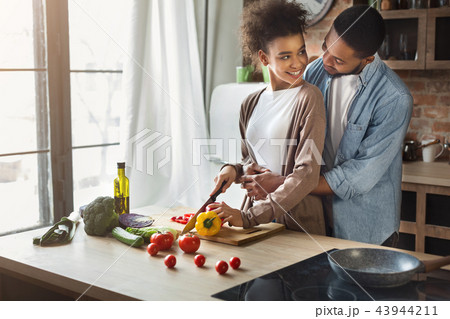 Loving black husband hugging wife while cooking 43944211