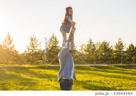 Fatherhood, family and children concept - Father and daughter having fun and playing in nature. Fatherhood, family and children concept - Father and daughter having fun and playing in nature. 43949264