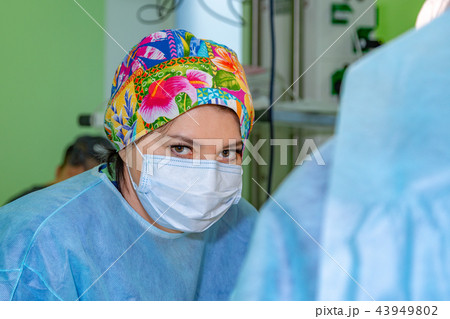 female surgeon doctor wearing protective mask and hat during the operation. Healthcare, medical female surgeon doctor wearing protective mask and hat during the operation. Healthcare, medical 43949802